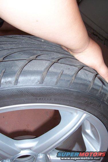Close-up of a worn tire on a silver alloy wheel
