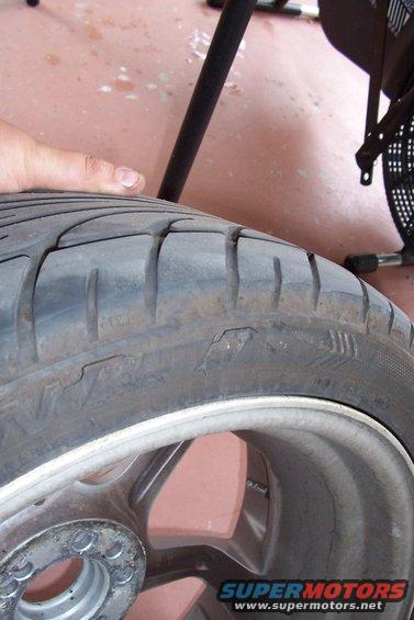 Close-up of a worn tire on a silver alloy wheel