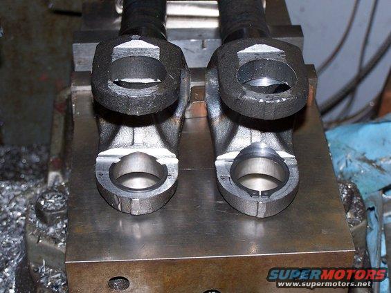 Two u-joints on a metal surface with Supermotors.net logo