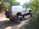 1992 Chevrolet S10 - This SUV is shown off-roading on a dirt path surrounded by trees.