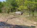 1992 Chevrolet S10 - A vehicle is stuck in a muddy trail, with trees and vegetation in the background.