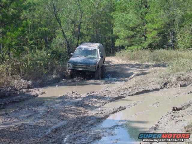 Blue 1992 Chevrolet S10 driving through mud on a dirt road