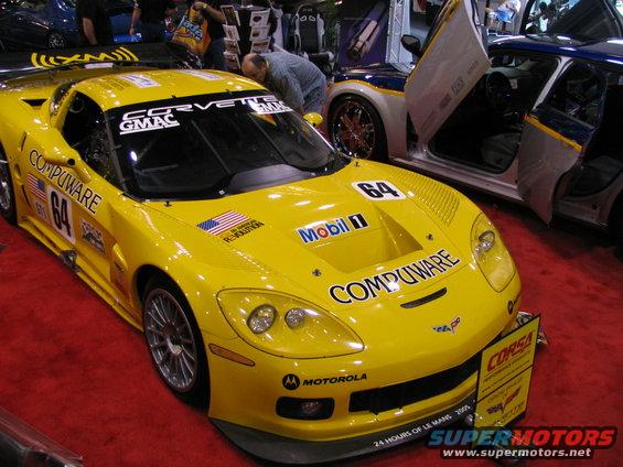 Yellow race car with 'COMPUWARE' and '64' decals, seen at an auto show