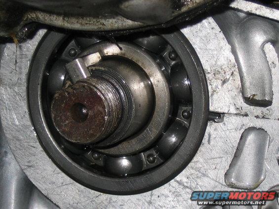 Close-up of a ball bearing with a threaded shaft and retaining clip