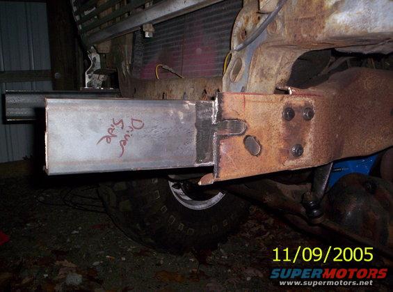 Welded steel tube extension on rusty frame with 'Drive Side' written in red marker