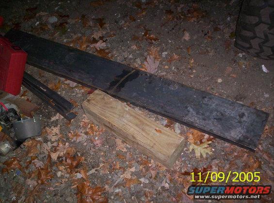 Tire tread and debris on the ground, with a wooden block and metal bar