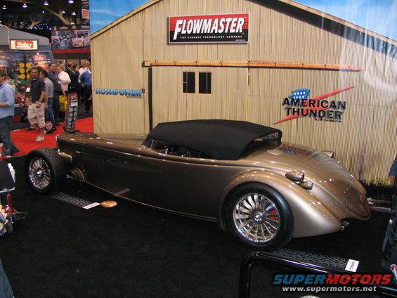 Brown convertible hot rod with black top and custom wheels