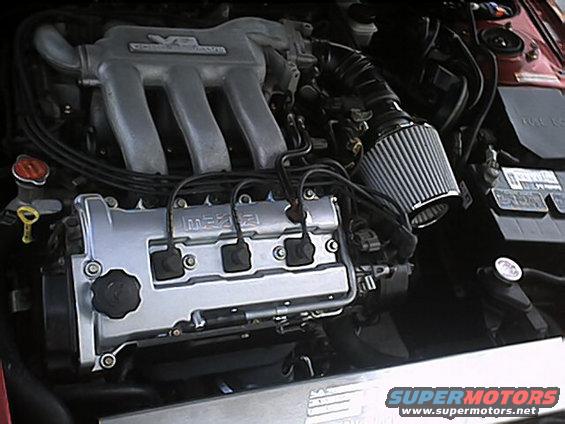 Mazda V6 engine with aftermarket air filter and red fender