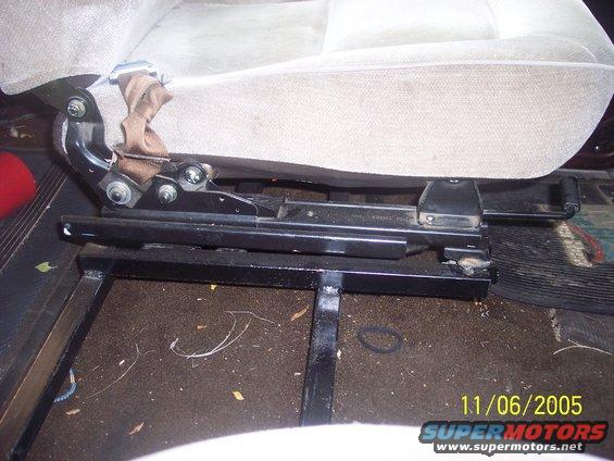 Close-up of a vehicle seat's metal bracket and slider mechanism