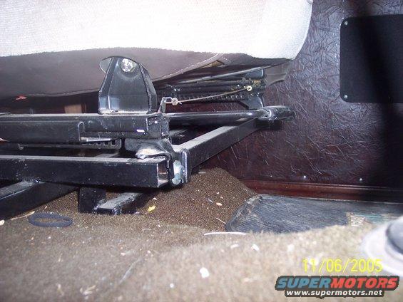 Close-up of vehicle seat mounting hardware and rails