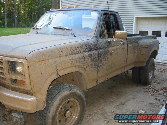 Mud-covered dually pickup truck, 3/4 front view. Appears to be from the early 1980s