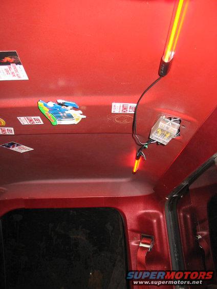 Interior roof of a red vehicle with various stickers and two yellow LED lights installed