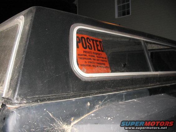 Black truck cap with orange posted sign on window