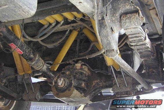 Undercarriage view of yellow shock absorbers and leaf springs