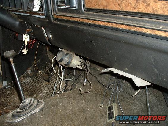 Interior view of a vehicle with a floor shifter, dashboard, and dual gauges