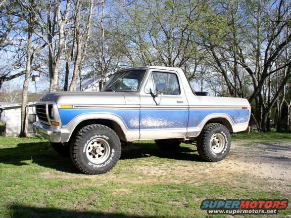 1979 Ford Bronco with blue and silver paint, parked on grass