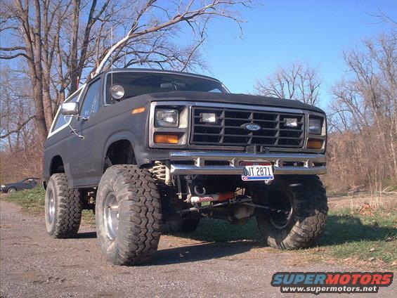 Dark gray Ford Bronco with lifted suspension and large tires, front view