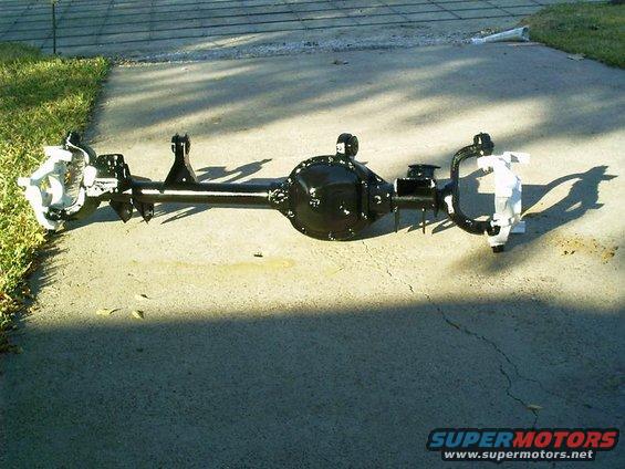 Rear axle assembly, painted black, sitting on concrete