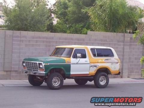 Ford Bronco with green, white, and yellow paint job parked on a street