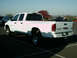 2002 Ford F-250 - This white Dodge Ram 3500 pickup truck is parked in a lot on a sunny day.