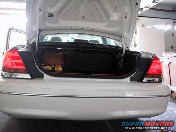 White 2003 Ford Crown Victoria rear with open trunk showing spare tire and luggage