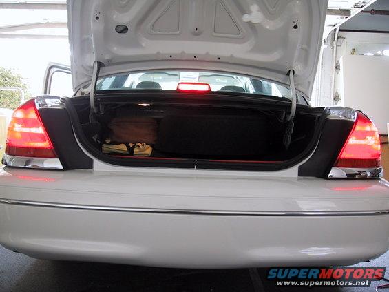 2003 Ford Crown Victoria trunk open, showing luggage and spare tire