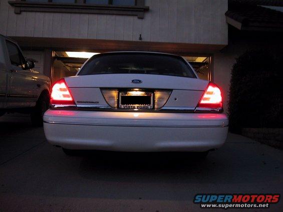 White 2003 Ford Crown Victoria rear view with brake lights illuminated