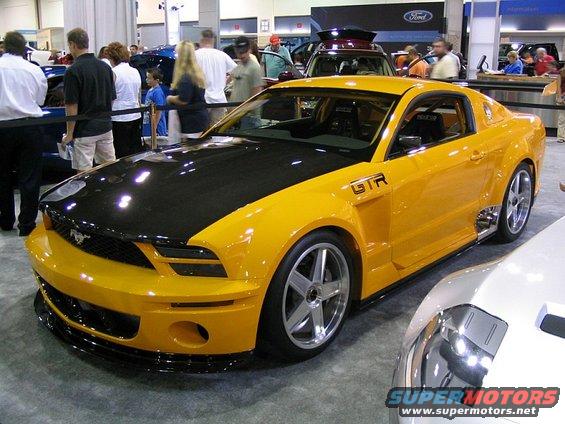 Yellow and black Ford Mustang with GTR badging, custom wheels, and black hood