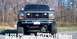 1986 Ford Bronco - Front view of a lifted 1986 Ford Bronco with large mud tires and custom grille.