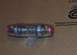 1985 Ford Crown Victoria LTD - A clear inline fuse holder with red end caps is shown against a brown background.