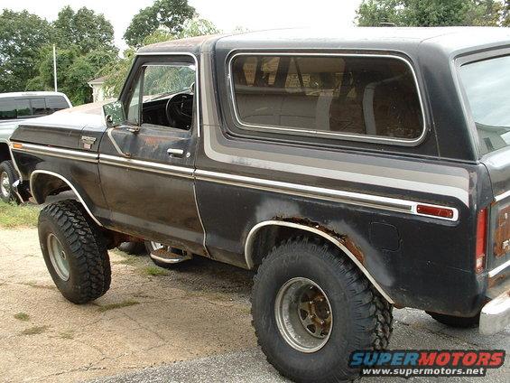 Black 1978 Ford Bronco with chrome trim and rust spots, viewed from the side