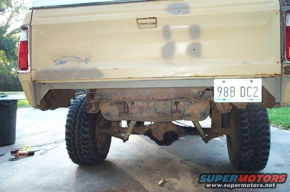 Rear of tan pickup truck with fish decal and license plate 98B DC2