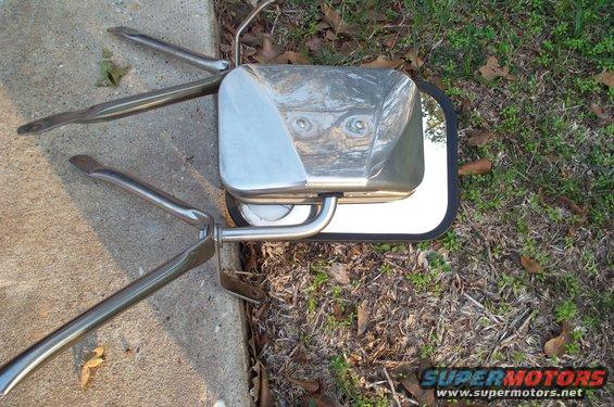 Chrome side mirror assembly with two mounting arms on concrete and grass