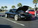 1994 Ford Probe - A black 1994 Ford Probe is displayed with its hood open, alongside another vehicle in a parking lot.