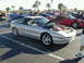1994 Ford Probe - Several cars are parked in a lot, with one silver coupe's hood open to reveal the engine.