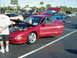 1994 Ford Probe - Several cars are displayed with hoods and doors open at an outdoor car show.