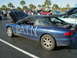 1994 Ford Probe - A blue coupe with 'BATN' written in white on its side and hood, parked in a lot with other vehicles.