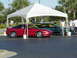 1994 Ford Probe - Two cars, a red sports car and a green sedan, are parked under a white tent at an outdoor event.