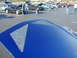 1994 Ford Probe - A blue car's hood with distinctive mesh vents is shown, with a car meet in the background.