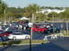 1994 Ford Probe - A collection of cars are gathered in a parking lot, with several people milling about.