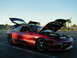 1994 Ford Probe - A red 1994 Ford Probe is parked with its hood and trunk open under a clear sky.