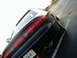 1994 Ford Probe - The rear of a black sports coupe is visible, parked at an angle in a lot with a white line on the asphalt.