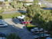 1994 Ford Probe - A variety of vehicles are parked in an outdoor lot, surrounded by lush greenery and palm trees.
