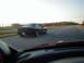 1994 Ford Probe - A black coupe is seen from behind on a highway under a bright sky.