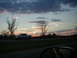 1994 Ford Probe - A pickup truck travels down a highway during a dramatic sunset with scattered clouds.