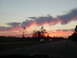 1994 Ford Probe - A scenic sunset over a highway, with two cars visible in the distance and colorful clouds painting the sky.