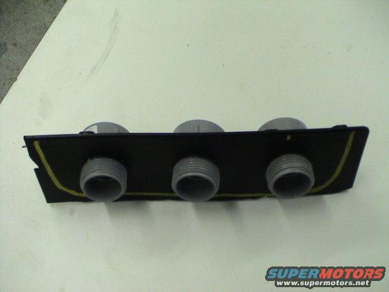 Center console part with three circular openings and yellow trim