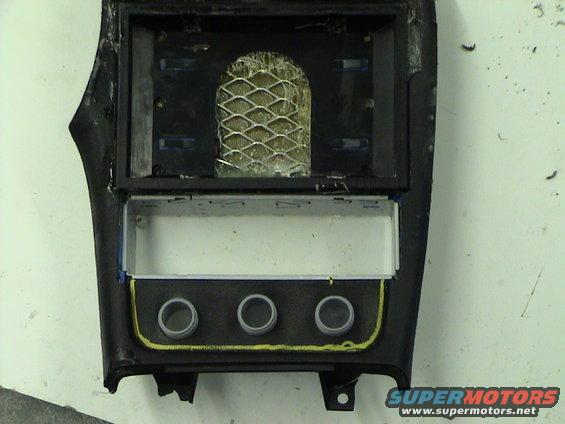 Car center console trim piece with openings for radio and three knobs