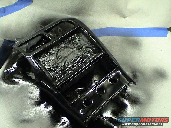 Black center console part with multiple compartments and openings