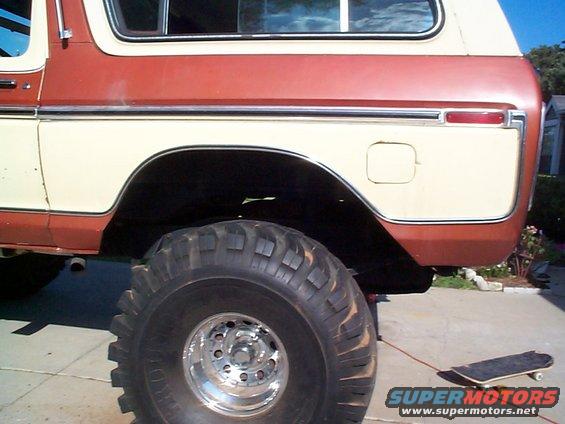 Two-tone red and cream Ford Bronco rear quarter panel with large off-road tire